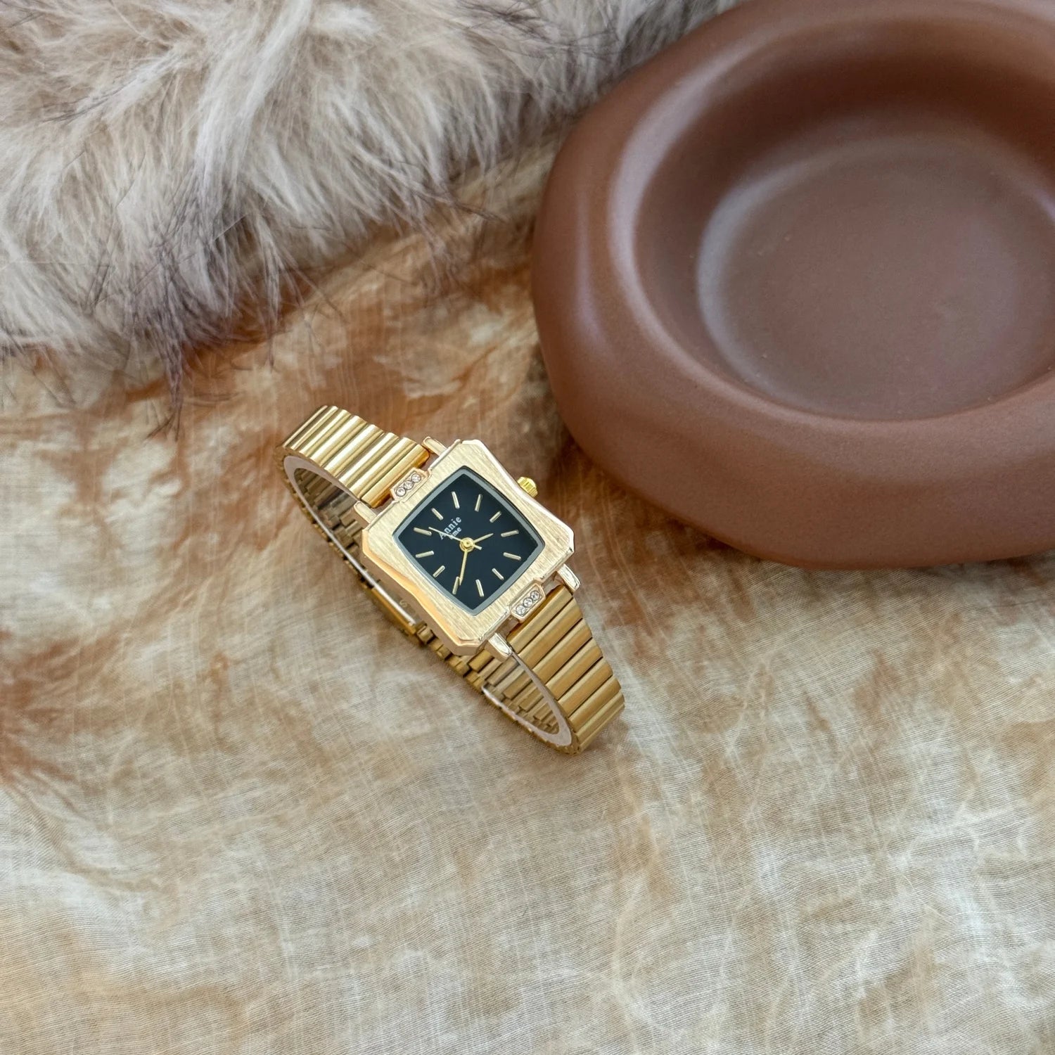 Montre élégante et simple, avec bracelet en acier inoxydable doré et réglable. Cadran carré raffiné.