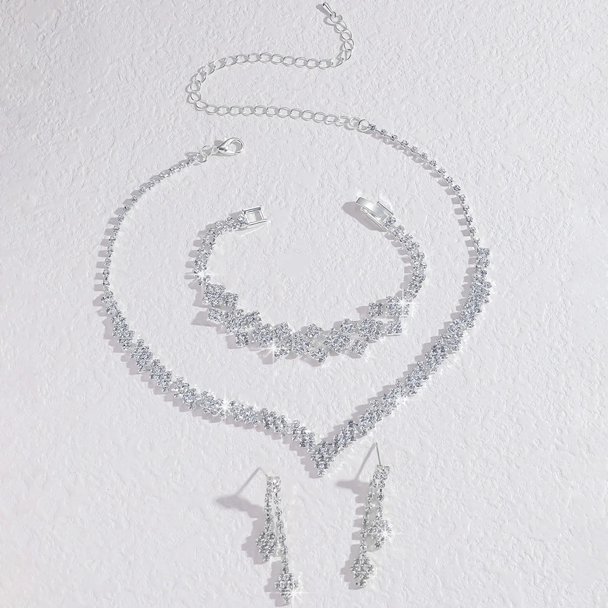 Boucles d’oreilles et collier à pampilles pliantes en strass plaqué argent.