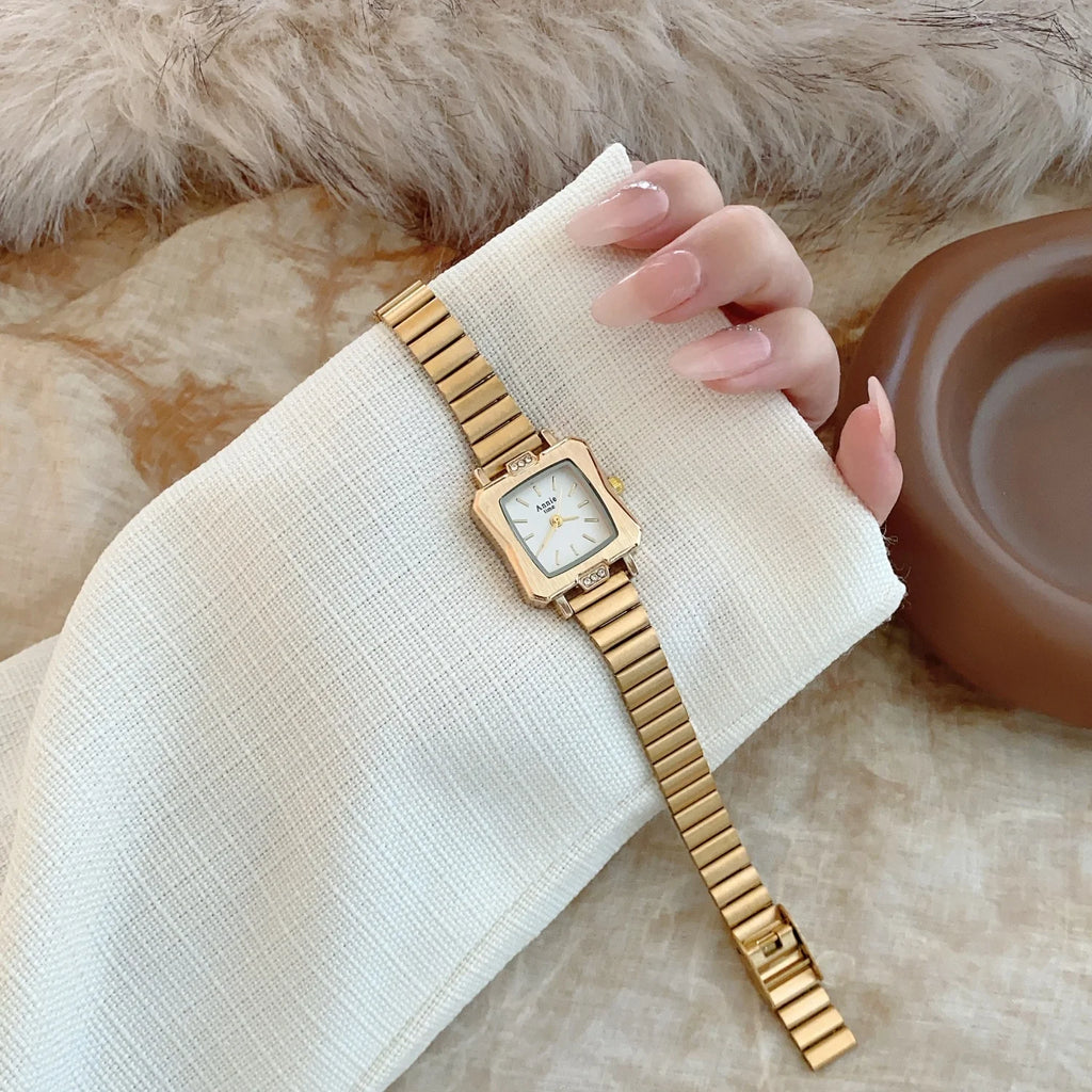 Montre élégante et simple, avec bracelet en acier inoxydable doré et réglable. Cadran carré raffiné.