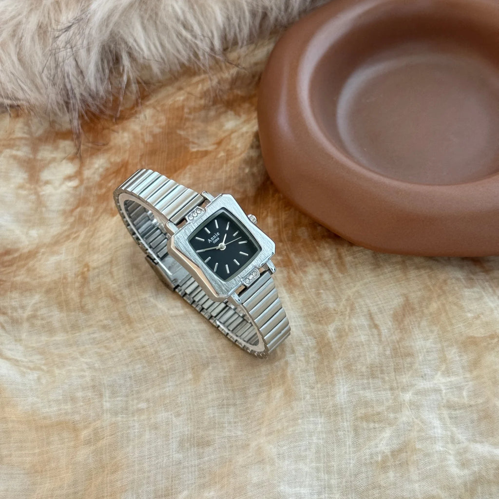 Montre élégante et simple, avec bracelet en acier inoxydable doré et réglable. Cadran carré raffiné.