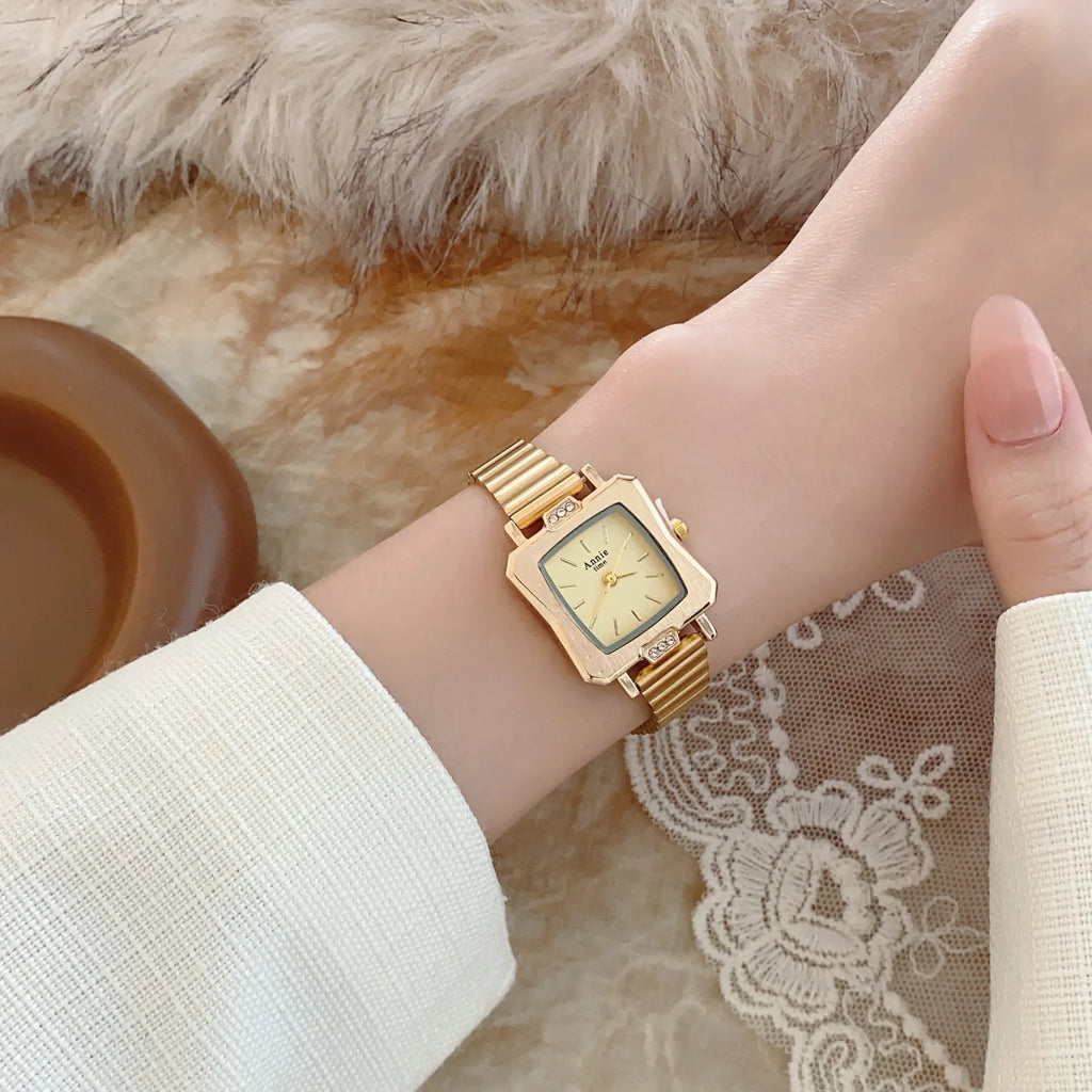 Montre élégante et simple, avec bracelet en acier inoxydable doré et réglable. Cadran carré raffiné.